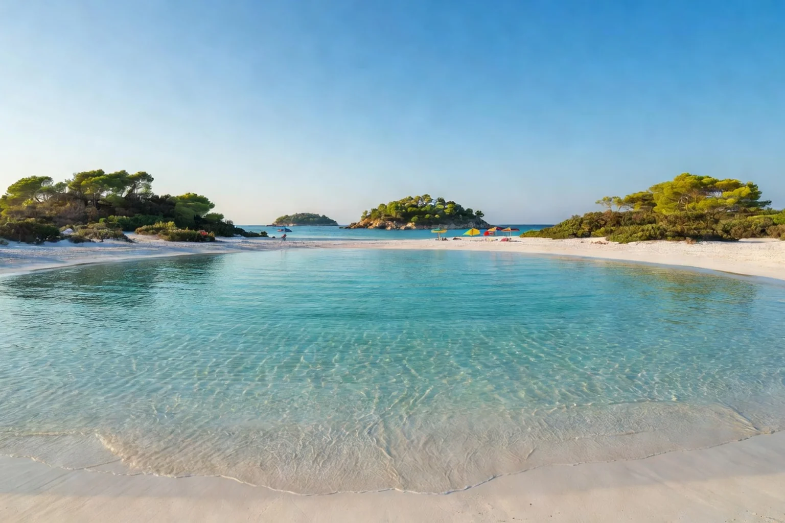 Crique de sable blanc de Ksamil avec eaux turquoise et îlots boisés au large