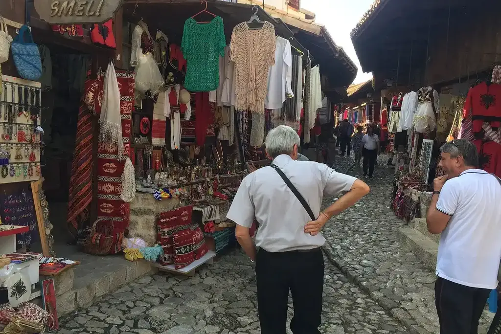 Ruelles pavées du vieux bazar de Krujë avec étals d'artisanat et arcades ottomanes